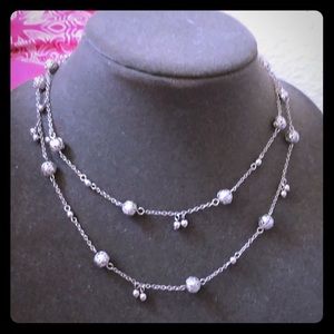 Long globe figure necklace.